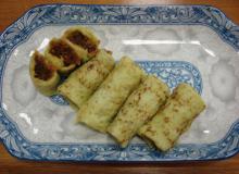 Kueh Dadar on a plate decorated with a typical Peranakan design.